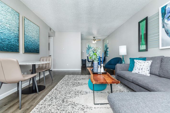 a living room with a couch, coffee table and a painting at The Starburst Apartments