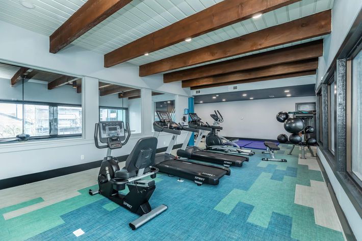 a gym room with exercise equipment and blue walls at The Starburst Apartments